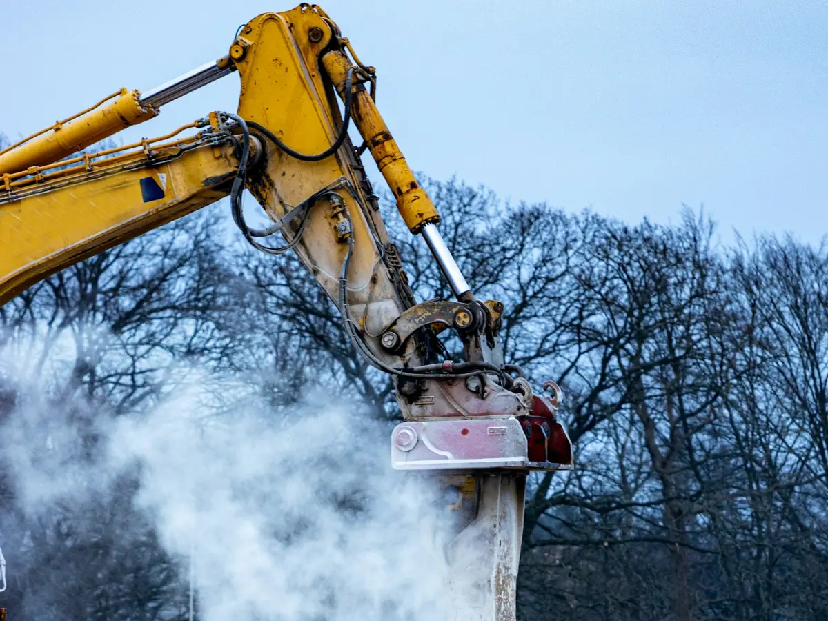Excavator processing steel and debris on a commercial demolition site